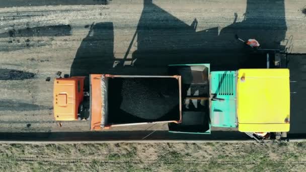 Las máquinas trabajan con asfalto en una carretera. Vista aérea de los trabajos en carretera . — Vídeo de stock