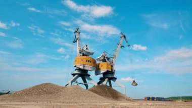 İki yük aracı çakılları hızlı hareket ettiriyor.