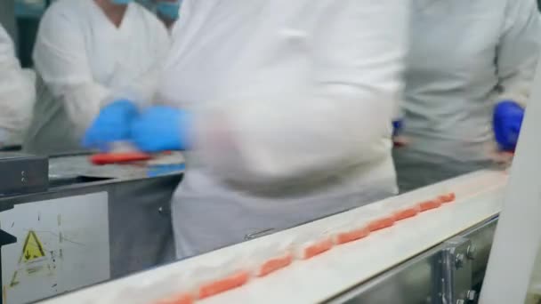 Factory technicians are removing crab sticks from the belt — Stock Video