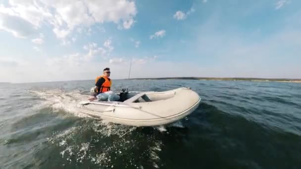 Motorboot wordt behandeld door een man in een reddingsvest — Stockvideo