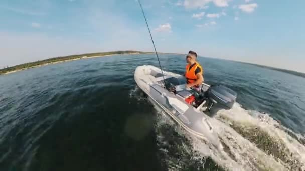 Um homem está a atravessar o lago no barco automático. — Vídeo de Stock