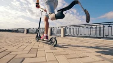 Sakat bir adamın scooter sürdüğü rıhtımda.