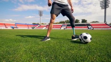 Engelli oyuncu ağır çekimde top sürüyor.