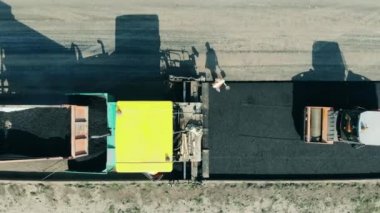 Asfalt üzerine çakıl döşeyen makineler.