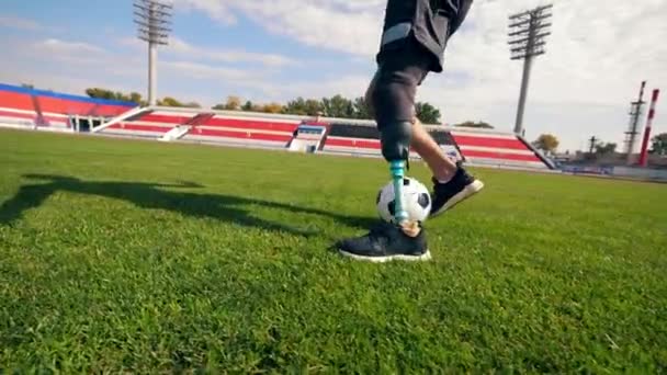 Футболист с бионической ногой бежит с мячом — стоковое видео