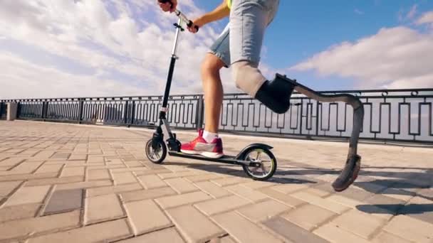 Bacak yedeği olan bir adam scooter kullanıyor. — Stok video