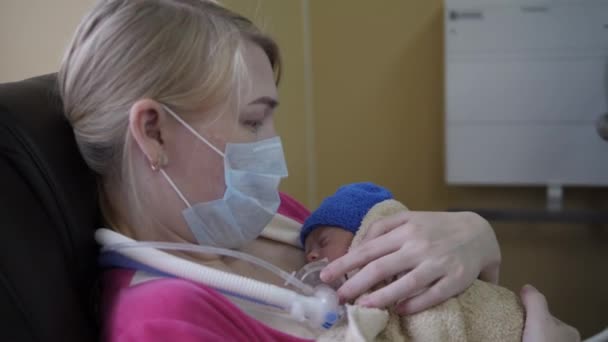 Woman holds newborn baby with tubes. — Stock Video