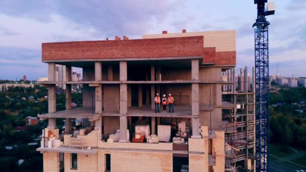 Travailleurs de la construction dans le bâtiment à plusieurs étages en cours — Video