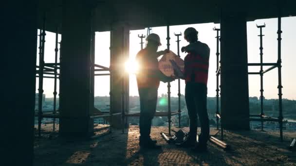 두 명의 건설 기술자 가 건물 설계를 하고 있는 모습 — 비디오