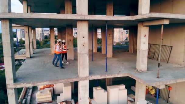Edifício alto em andamento com arquitetos caminhando ao longo dele — Vídeo de Stock