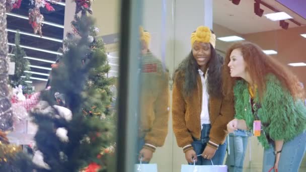 Dois amigos verificam decorações de Natal em vitrines . — Vídeo de Stock