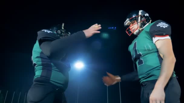 Two american football players shaking hands before a game, close up. — Stock Video