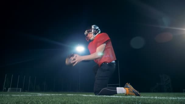 Jugador de fútbol americano patea una pelota hacia las puertas, vista trasera . — Vídeo de stock