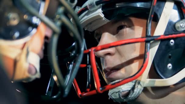 Sportler, American Football-Spieler stehen Kopf an Kopf auf einem Feld, Seitenansicht. — Stockvideo