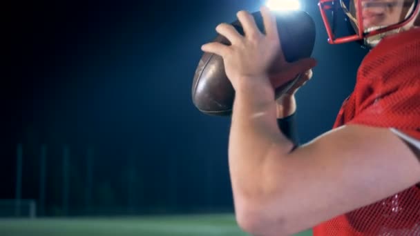 Jugador de fútbol americano listo para lanzar una pelota, de cerca . — Vídeo de stock