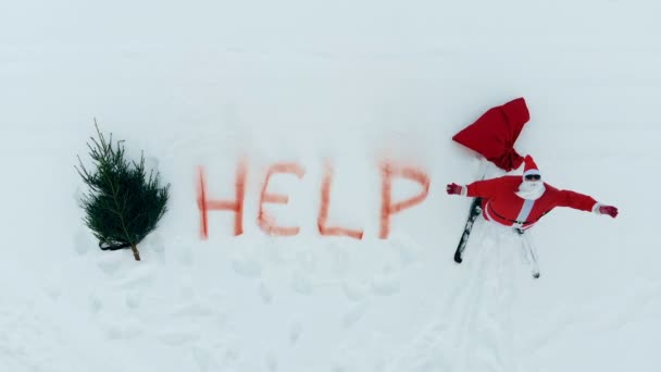 La palabra ayuda está escrita en la nieve cerca de llorar Santa Claus — Vídeo de stock