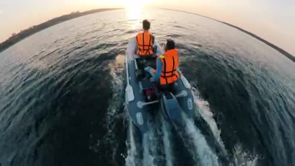 Dinghy z dwoma mężczyznami na pokładzie przekracza rzekę w górnej części widoku — Wideo stockowe