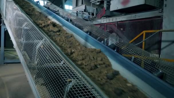 Kameny a písek pohybující se na výrobní lince. — Stock video