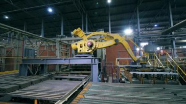 Robot kol, modern bir fabrikaya tuğla taşır, endüstriyel bir fabrikaya..