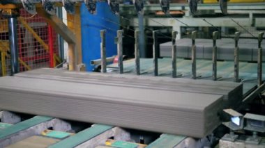 Fabrika makinesi tuğlaları bir hatta kesiyor..