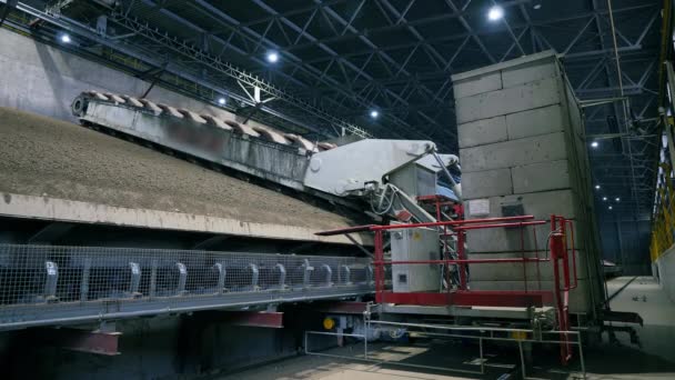 Máquina de trabajo mueve piedras trituradas en una instalación . — Vídeos de Stock