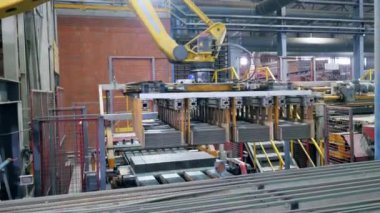 Robot kol, bir santraldeki bir hatta tuğla yerleştiriyor..