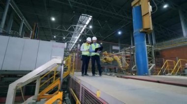 Adamlar bir fabrikaya girip dizüstü bilgisayarla çalışıyorlar. Modern bir fabrikada fabrika erkek mühendisleri..