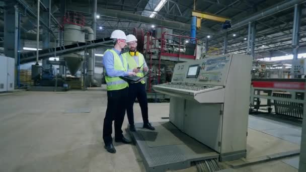 Ingenieros masculinos de fábrica en una fábrica moderna. Trabajadores revisan máquinas de fábrica en una planta industrial moderna . — Vídeos de Stock