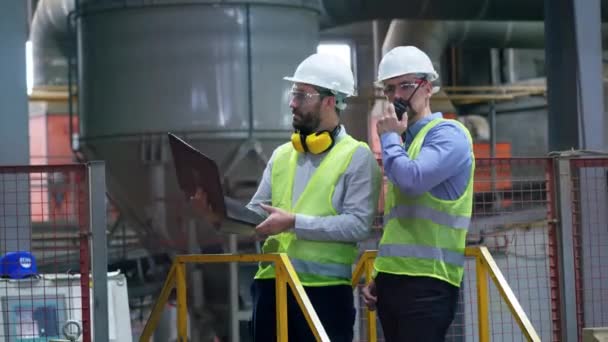 Професійні працівники заводу на заводі. Люди працюють на цегляному заводі, використовуючи ноутбук . — стокове відео