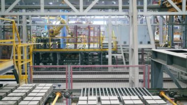 Robot kollar modern bir endüstriyel fabrikada tuğlalarla paletleri hareket ettirir.