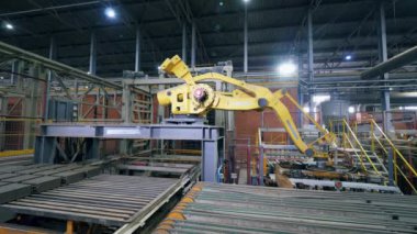 Modern fabrika makinesi tesisteki bir taşıyıcıdan tuğla taşıyor..
