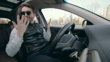 Kendi kendine giden otonom araba kendi kendine park ediyor. Bir adam otomatik bir aracın tekerleğine dokunmaz.
