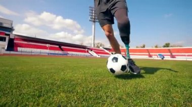 Futbol sahası ve top süren bir erkek felçli.