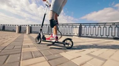 Mobilete binen protez bacaklı bir adamın yavaş hareketi.