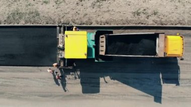 Yol inşaatında çalışan inşaat işçileri. İşçiler Bitum 'u yola saçıyor.