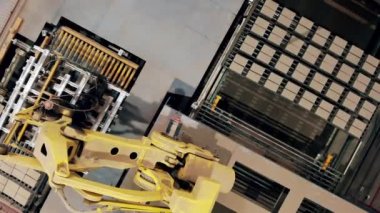 Modern fabrikada robot manipülatörü. Tuğlalar hareket ediyor ve mekanik olarak üst görüntüye yerleştiriliyor