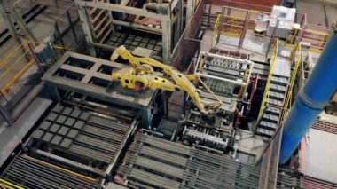 Endüstriyel fabrikada çalışan otomatik robot kolu.