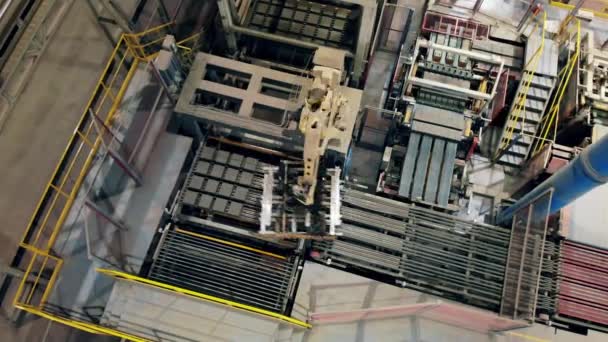 Top view of a robotized arm moving batches of bricks at amodern factory floor. — Stock Video