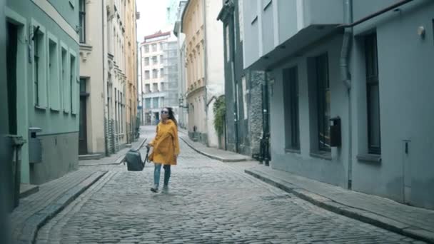 Calle estrecha y una dama felizmente caminando a lo largo de ella — Vídeos de Stock
