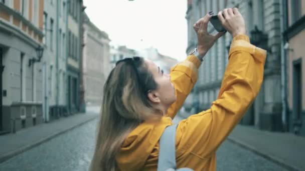 Pohled zezadu na ženskou turistku, která fotí pouliční budovy — Stock video