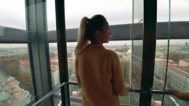 En dam går upp i en genomskinlig hiss — Stockvideo