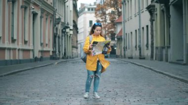 Şehir caddesinde bir kadın turist manzaraya bakıyor.