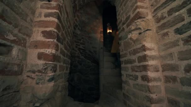Eski merdivenler ve elinde fenerle yürüyen bir kadın. — Stok video