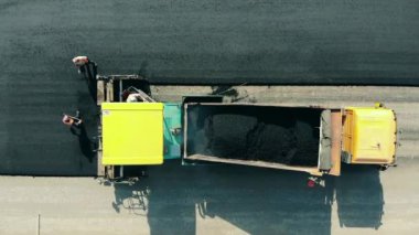 Fresh bitum is getting mechanically placed onto the road