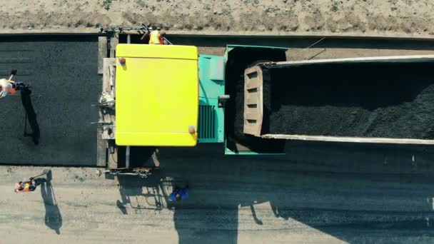 Los trabajadores de la carretera están poniendo mordisco en el camino fresco. Máquina de asfalto en un sitio de construcción de carreteras . — Vídeos de Stock