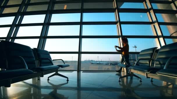 한 여성 이 출국 라운지에서 노트북으로 일하고 있습니다. — 비디오