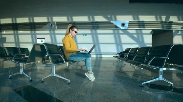 Wartehalle am Flughafen mit einer Dame, die am Computer arbeitet — Stockvideo