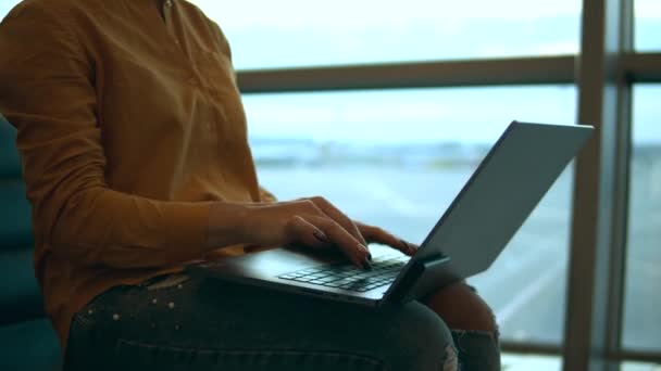Närbild av kvinnliga händer skriva på en bärbar dator på flygplatsen — Stockvideo