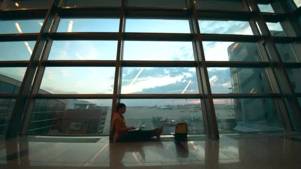 Зал ожидания аэропорта и дама с ноутбуком, сидящая на полу — стоковое видео
