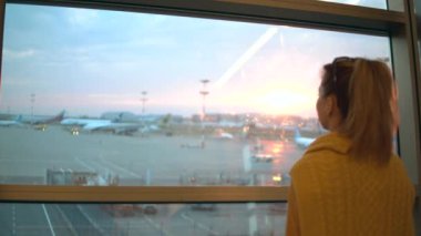 Kadın havaalanının kalkış yerine bakıyor.
